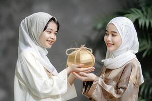 ai generado dos hembra compartiendo kétupat, indonesio arroz pastel popular para eid Alabama fitr y eid Alabama adha banquete foto