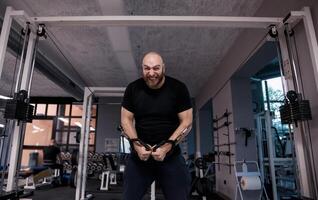 athlete while doing heavy exercises at the cables photo