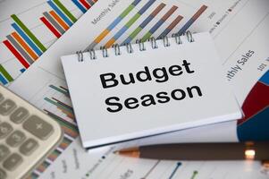 Budget season text on notepad with business analysis background photo