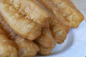 Close up of cakoi or Youtiao on white plate with customizable space for text. Asian food concept photo