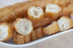 Close up of cut cakoi or youtiao cake on white plate. Asian food concept photo