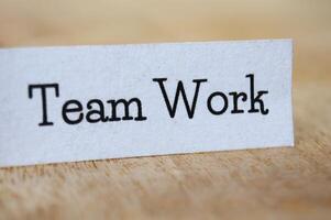 Team work text on white paper on wooden table photo