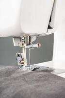 Modern sewing machine with gray fabric photo