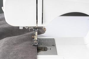 Modern sewing machine with gray fabric photo