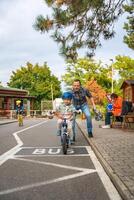 Prague, Czech republic - October 10, 2023. Happy father teaches child daughter to ride public bike on one of traffic playground in Prague, Czech republic, Europe. High quality photo