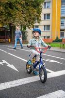 Happy family father teaches child daughter to ride public bike on one of traffic playground in Prague, Czech republic, Europe. High quality photo