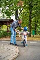 Family father teaches child daughter to ride public bike on one of traffic playground in Prague, Czech republic, Europe. High quality photo