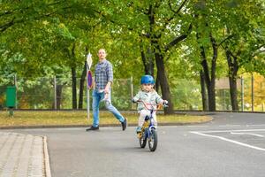 Happy family father teaches child daughter to ride public bike on one of traffic playground, Prague in Czech republic, Europe. High quality photo