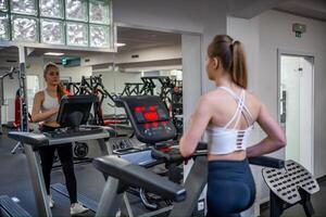 Young woman going on treadmill machine in fitness club. . High quality photo