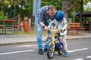 Young father teaches child daughter to ride public bike on one of traffic playground of Prague, Czech republic, Europe. High quality photo