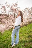 encantador joven mujer en un floreciente rosado y blanco jardín petrin en praga, primavera hora en Europa. alto calidad foto