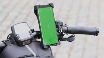 joven mujer utilizando teléfono inteligente con verde pantalla Bosquejo montado en bicicleta manillar a navegar mapas aplicación, seleccionando bicicleta ruta, alto calidad 4k imágenes video