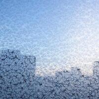 frosty pattern on home window glass on winter day photo