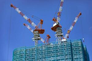 Cranes at the under construction daytime long shot photo