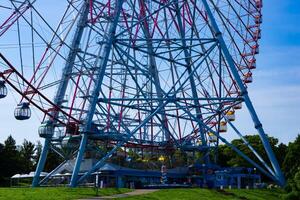 un ferris rueda a el parque detrás el azul cielo telefotográfico Disparo foto