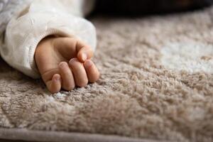 A left hand of sleeping asian baby on the carpet photo