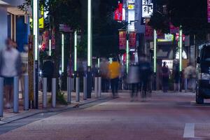 un noche paisaje urbano de el multitud a el neón pueblo en Shinjuku tokio largo Disparo foto