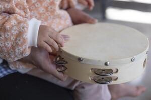 Child's hands with tambourine in the living room closeup photo