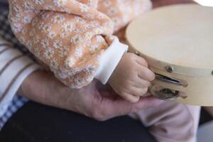 Child's hands with tambourine in the living room closeup photo