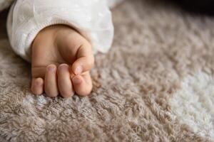 A left hand of sleeping asian baby on the carpet photo