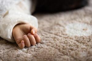 A left hand of sleeping asian baby on the carpet photo