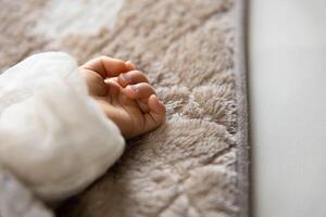 A left hand of sleeping asian baby on the carpet photo