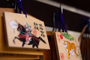 A votive wooden tablet at Tomioka Shrine close up photo