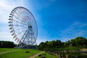 A ferris wheel at the park behind the blue sky wide shot photo