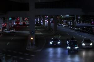 un noche miniatura tráfico mermelada a el urbano calle en tokio foto