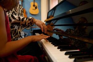 de cerca ver de el manos de un músico profesor y niña dedos conmovedor el piano llaves, explicando el correcto posiciones de dedos mientras aprendizaje jugar piano y capturar el ritmo de música foto