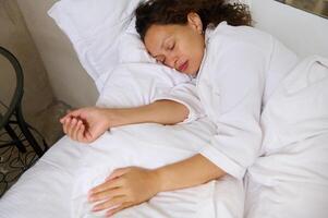 Woman sleeping in her comfortable bed photo