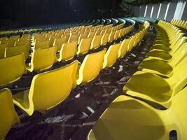 Empty chairs in the stands of the movie theater. Many empty seats for spectators. photo