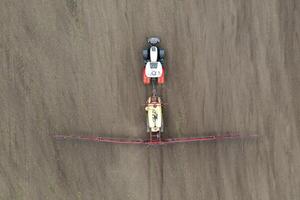 Top view of tractor spraying grain on a field. photo