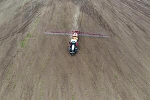 Top view of tractor spraying grain on a field. photo