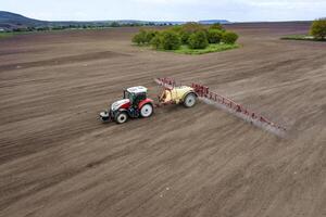 Aerial view of field and tractor spraying grain photo