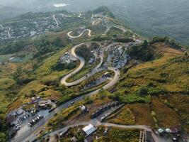 un aéreo perspectiva vitrinas el intrincado red de devanado carreteras serpenteante mediante el montañoso paisaje a el descanso de amanecer foto