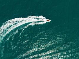 Aerial view of Speed boat at high speed in the aqua sea, Drone view photo