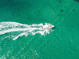 Aerial view of Speed boat at high speed in the aqua sea, Drone view photo