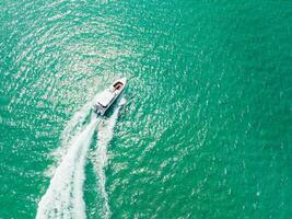 Aerial view of Speed boat at high speed in the aqua sea, Drone view photo