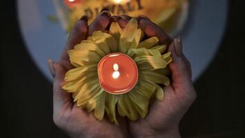 Celebration of the religious Indian festival of Diwali. Yellow flowers with burning holi candles at Hindi festival close-up photo