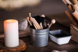 Ceramics. Objects for working with clay, stacks, sticks, brushes standing in a bucket photo