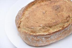 A fresh loaf of bread on a plate.  A piece of delicious bread. Bakery products. photo