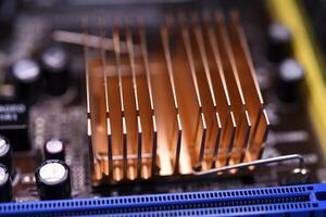 A copper radiator for cooling the chip on the computer board. Radio components.The computer's motherboard. photo