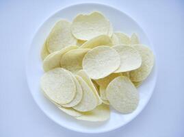 patata papas fritas en un platillo en un blanco antecedentes. ellos verter el papas fritas fuera de el caja. un delicioso bocadillo. foto