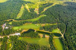 Top view of the golf course located in a wooded area photo