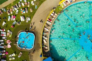 Top view of an outdoor place for people to relax where there is a swimming pool and a lot of sun beds photo