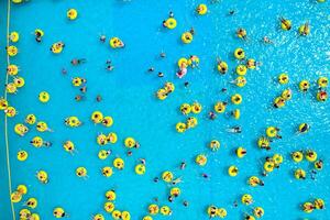 Top view of People relaxing in the pool on yellow inflatable circles photo