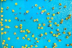 Top view of People relaxing in the pool on yellow inflatable circles photo