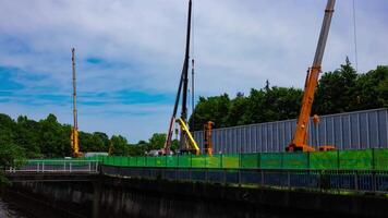 A timelapse of moving cranes at the under construction in Tokyo tilt video