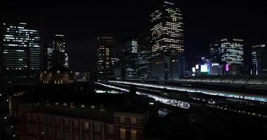 un' notte panoramico paesaggio urbano nel davanti di tokyo stazione largo tiro video